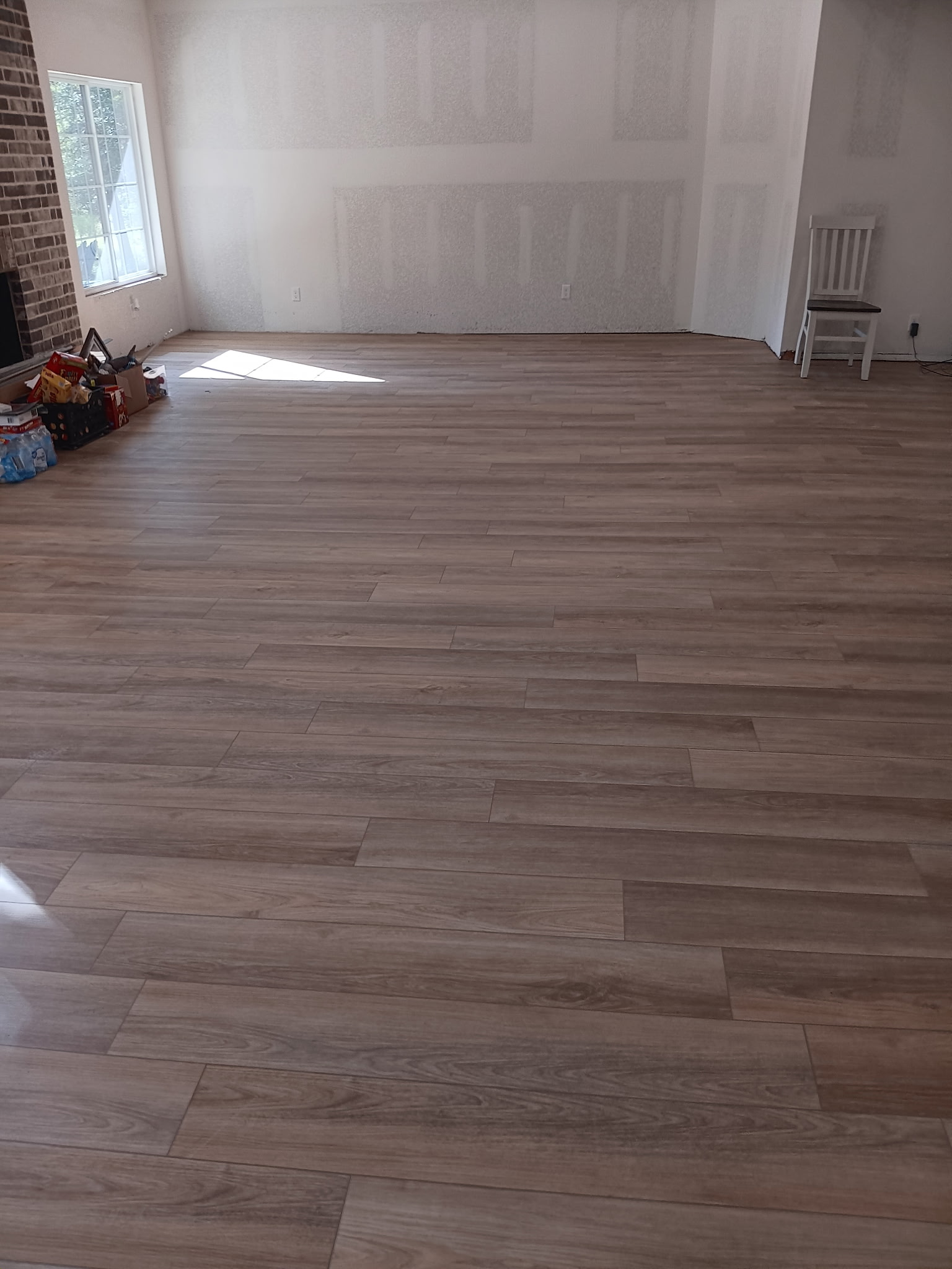 Interior room with new flooring and drywall seams still visible before paint