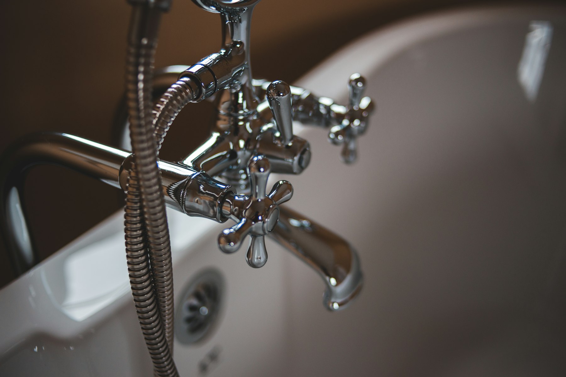 Chrome bathtub faucet and handheld shower installed on a residential tub