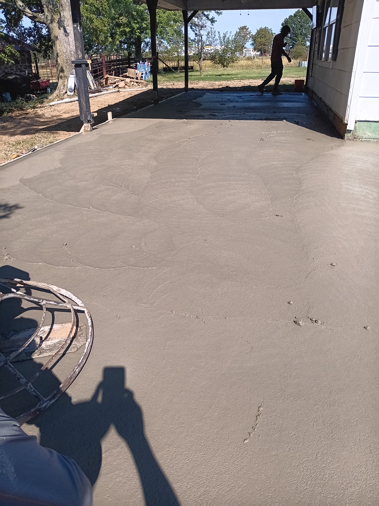 Fresh concrete patio poured under a covered residential porch